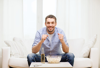 Image showing smiling man watching sports at home