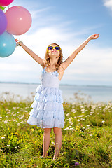Image showing happy girl waving hands with colorful balloons