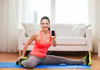 Image showing smiling teenage girl streching on floor at home