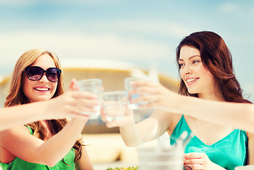 Image showing girls making a toast in cafe on the beach