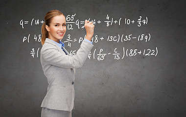 Image showing businesswoman writing formula with marker