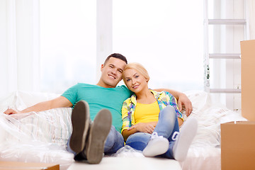 Image showing smiling couple relaxing on sofa in new home