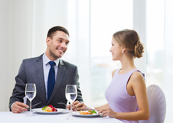 Image showing smiling couple eating main course at restaurant