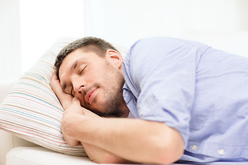 Image showing calm young man lying on sofa at home