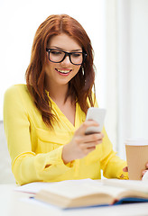 Image showing smiling student girl with smartphone at school