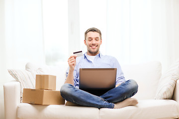 Image showing man with laptop, credit card and cardboard boxes