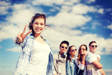 Image showing teenage girl with headphones and friends outside