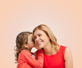 Image showing smiling mother and daughter whispering gossip