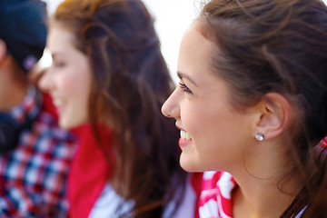 Image showing smiling teenage girl outdoors with friends