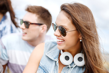 Image showing smiling teenage girl outdoors with friends