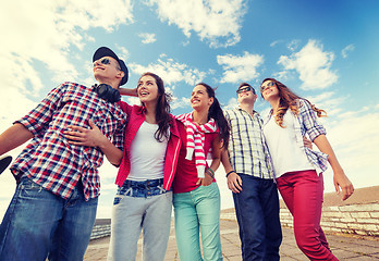 Image showing smiling teenagers in sunglasses hanging outside