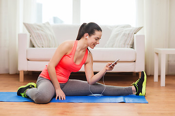 Image showing smiling teenage girl streching on floor at home