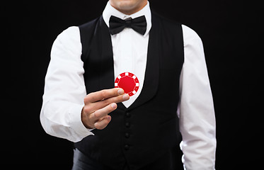 Image showing dealer holding red poker chip