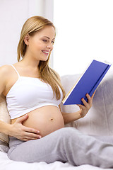 Image showing pregnant woman reading book at home