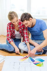 Image showing smiling couple looking at color samples at home