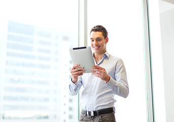 Image showing smiling businessman with tablet pc in office