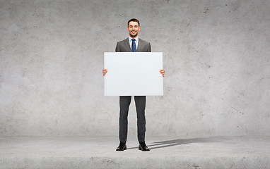 Image showing smiling businessman with white blank board