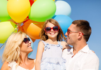 Image showing happy family with colorful balloons outdoors