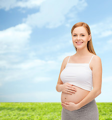 Image showing happy future mother touching her belly