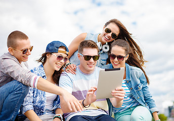 Image showing group of smiling teenagers looking at tablet pc