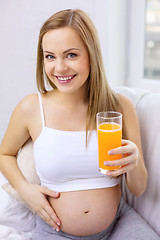 Image showing happy pregnant woman with fresh orange juice