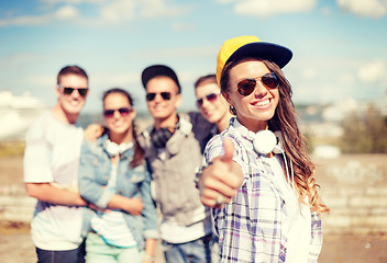 Image showing teenage girl with headphones and friends outside