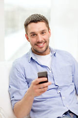 Image showing smiling man with smartphone at home