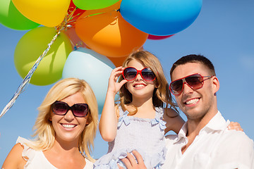 Image showing happy family with colorful balloons outdoors