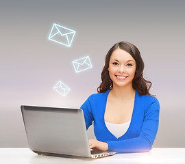 Image showing smiling woman in blue clothes with laptop computer