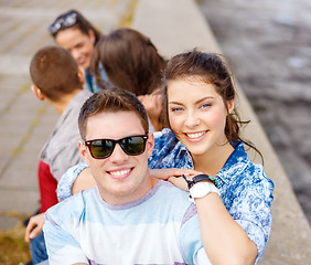 Image showing smiling teenagers in sunglasses having fun outside