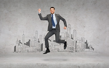 Image showing smiling businessman jumping