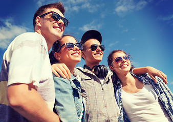 Image showing smiling teenagers in sunglasses hanging outside