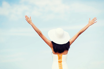 Image showing girl with hands up on the beach