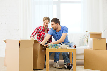 Image showing smiling couple unpacking kitchenware