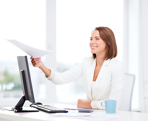 Image showing sming businesswoman giving papers in office