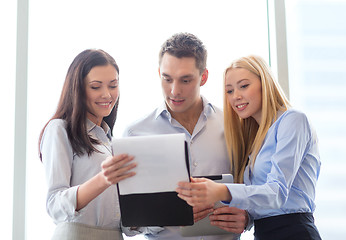 Image showing business team looking at clipboard