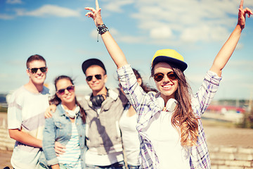 Image showing teenage girl with headphones and friends outside