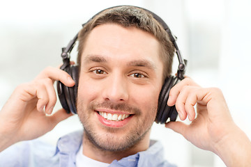 Image showing smiling young man in headphones at home