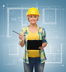 Image showing smiling woman in helmet with clipboard