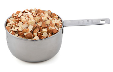 Image showing Chopped almonds in a metal cup measure