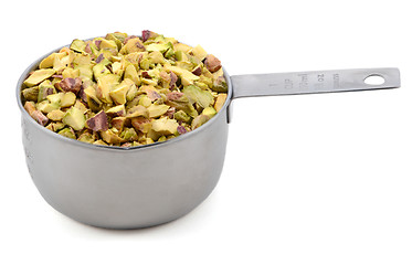 Image showing Chopped pistachio nuts in a metal cup measure