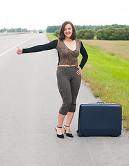 Image showing Woman with suitcase on road