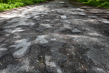 Image showing Damaged road full of cracked potholes in pavement