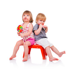 Image showing Babies eating a sticky lollipop