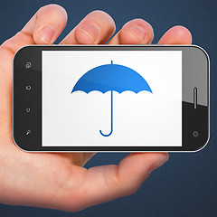 Image showing Safety concept: Umbrella on smartphone