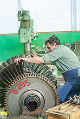 Image showing Mechanic assembles turbine for aviation engine