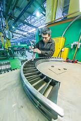 Image showing Worker assembles part for aviation engine