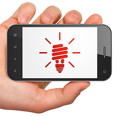 Image showing Finance concept: Energy Saving Lamp on smartphone