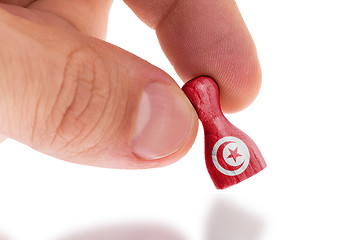 Image showing Hand holding wooden pawn, flag painting, selective focus