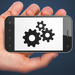 Image showing Advertising concept: smartphone with Gears.